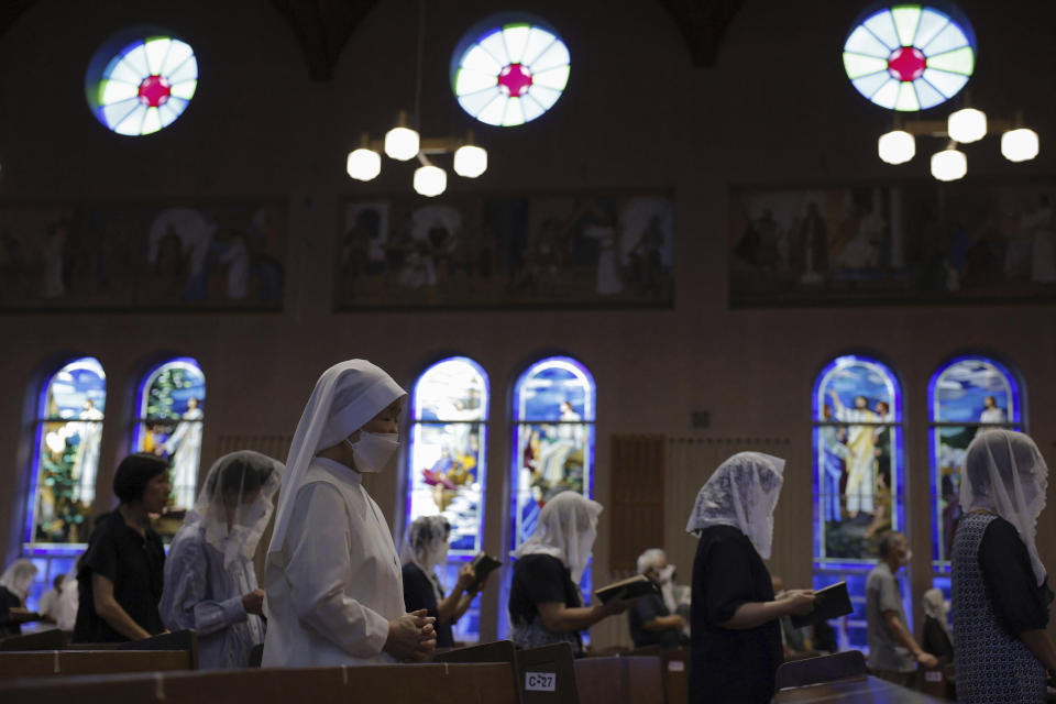 People attend an early morning Mass at the Urakami Cathedral on the 78th anniversary of the atomic bombing in Nagasaki, southern Japan, Wednesday, Aug. 9, 2023. Nagasaki holds its 78th peace memorial ceremony later Wednesday to mark the day an atomic bomb was dropped on the city. (Kyodo News via AP)