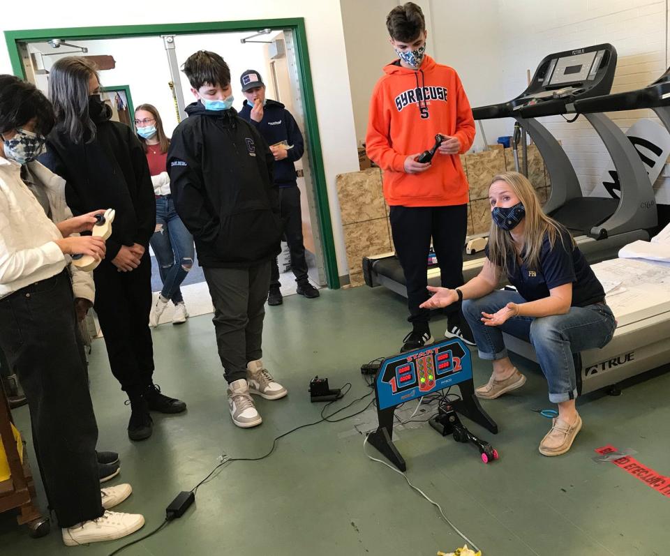 Learning can be fun: Hamilton Central School agriculture teacher Johanna Bossard, far right, and her Bossard 500 project give her eighth grade technology class plenty of education as they build and race their wooden cars.