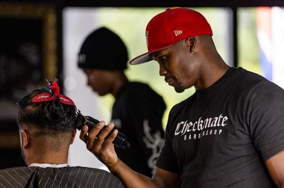 Neil Dhruve, left, gets his hair cut by Gregory Wright, barber and owner of Checkmate Barbershop in the Sistrunk neighborhood, on Tuesday, July 2, 2024, in Fort Lauderdale, Florida.