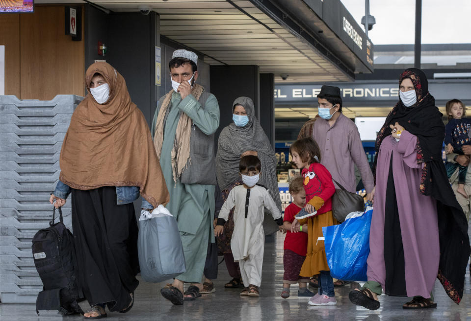 FILE - Families evacuated from Kabul, Afghanistan walk through the terminal to board a bus after they arrived at Washington Dulles International Airport, in Chantilly, Va., Sept. 1, 2021. Under President Joe Biden, the U.S. has relied heavily on humanitarian parole. The U.S. airlifted nearly 80,000 Afghans from Kabul, the capital of Afghanistan, and brought them to the U.S. after the Taliban takeover. (AP Photo/Gemunu Amarasinghe, File)