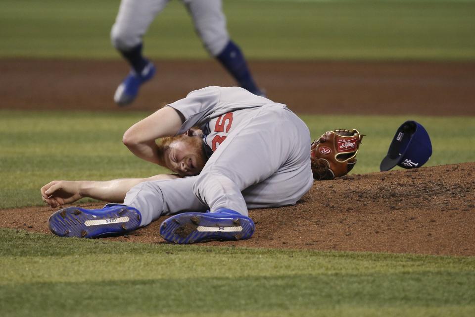 Los Angeles Dodgers relief pitcher Dustin May rolls on the ground after being hit by a batted ball from Arizona Diamondbacks' Jake Lamb during the fourth inning of a baseball game Sunday, Sept. 1, 2019, in Phoenix. (AP Photo/Ross D. Franklin)