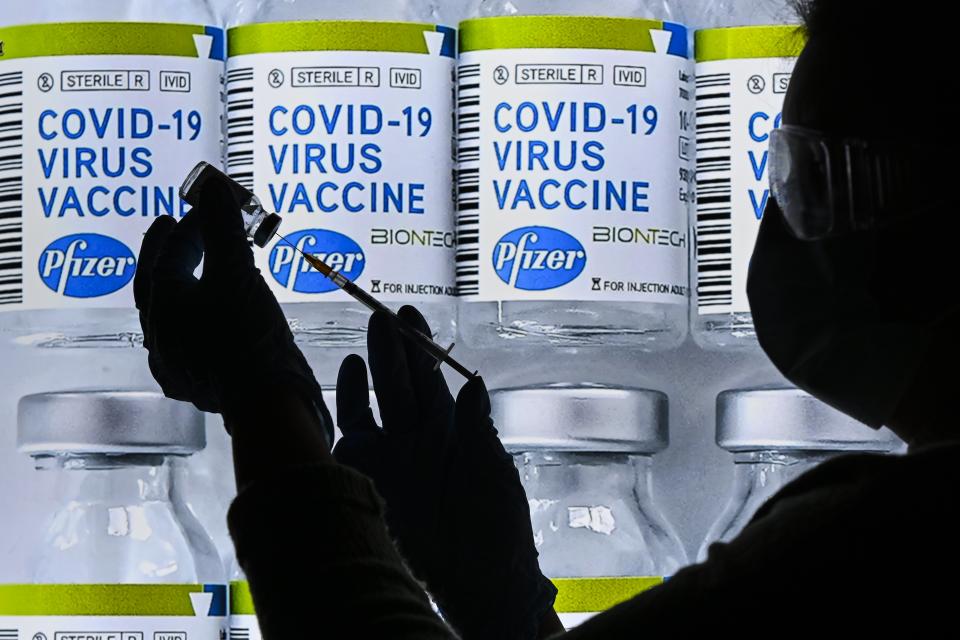 BRUSSELS, BELGIUM - NOVEMBER 23 : An illustration picture shows vials with Covid-19 Vaccine stickers attached and medical syringe with the US pharmaceutical company Pfizer and BioNTech German biotechnology company logos are seen in this creative photo. Pharmaceutical company Pfizer and BioNTech announced positive early results on its phase 3 study of Covid-19 vaccine candidate. Primary efficacy analysis demonstrates BNT162b2 to be 95% effective in preventing infection of the virus, as media reported on 18 November 2020. Pfizer Inc, in partnership with German company BioNTech SE, plans to supply 1.3 billion doses of the vaccine in 2021. Pictured on November 23, 2020 in Brussels, Belgium, 23/11/2020 ( Photo by Vincent Kalut / Photonews via Getty Images)