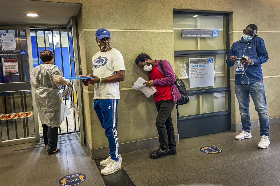 People who were just tested for COVID-19 wait in line to make payment for the test at a private laboratory in Johannesburg, South Africa, Saturday Dec. 19, 2020. South Africa is bracing for its second wave, as many people will travel across provinces for vacations and visiting their families. (AP Photo/Jerome Delay)