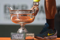Spain's Rafael Nadal lowers the trophy onto the podium after winning the final match against Norway's Casper Ruud in three sets, 6-3, 6-3, 6-0, at the French Open tennis tournament in Roland Garros stadium in Paris, France, Sunday, June 5, 2022. (AP Photo/Michel Euler)