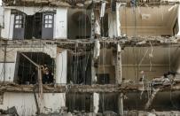 Palestinians clear rubble on November 14, 2018 in a building damaged by an Israeli air strike in the Gaza Strip