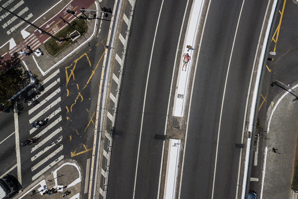 A man sunbathes on a median strip in Sao Paulo, Brazil, Saturday, Oct. 29, 2022. On Sunday, Brazilians head to the voting booth to choose between the top two presidential candidates who are facing each other in a runoff vote after neither got enough support to win outright in the Oct. 2 general election. (AP Photo/Matias Delacroix)