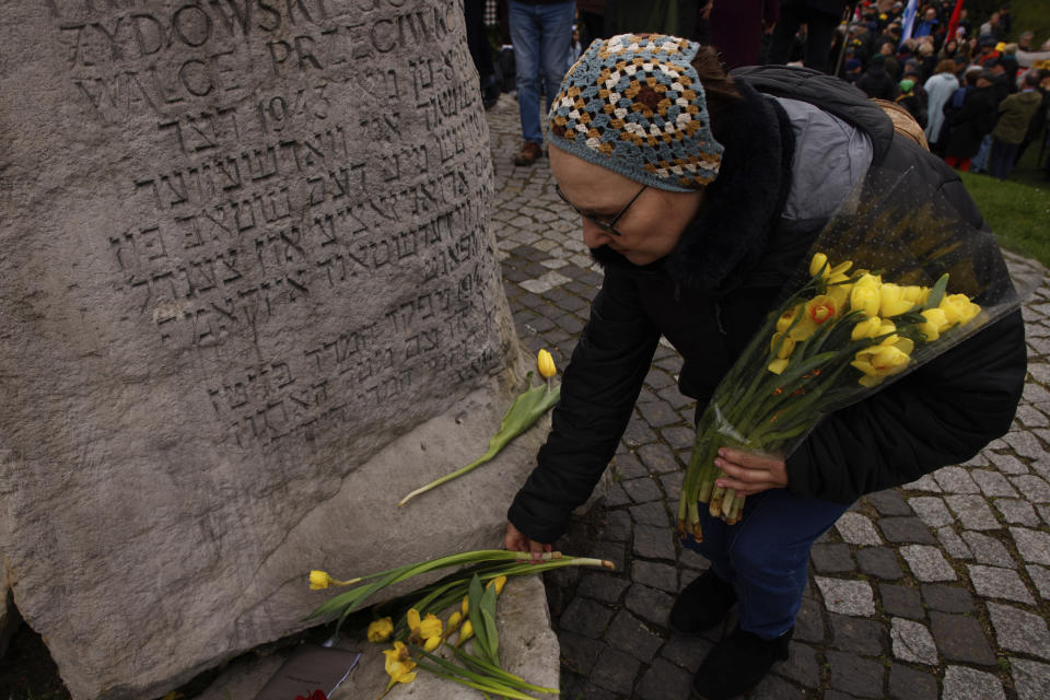 During personal unofficial observances marking the 80th anniversary of the Warsaw Ghetto Uprising a woman places tulips in Warsaw, Poland, Wednesday, April 19, 2023 in front of the memorial of the bunker where the leader of the doomed uprising, Mordechaj Anielewicz, and his comrades committed mass suicide. (AP Photo/Michal Dyjuk)