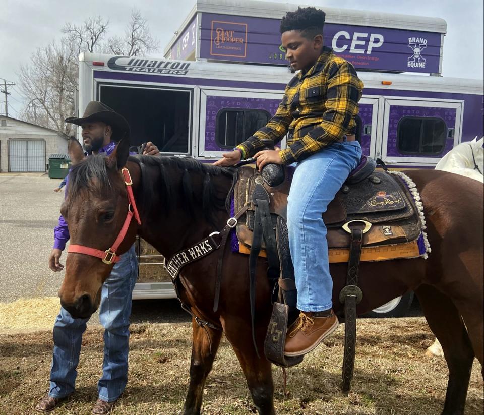 Tory Johnson with the Professional Rodeo Cowboys Association (PRCA) leads Samson Proctor around the church's back lawn on a horse during the 2023 "Pioneer Day" at Fifth Street Baptist Church in Oklahoma City.