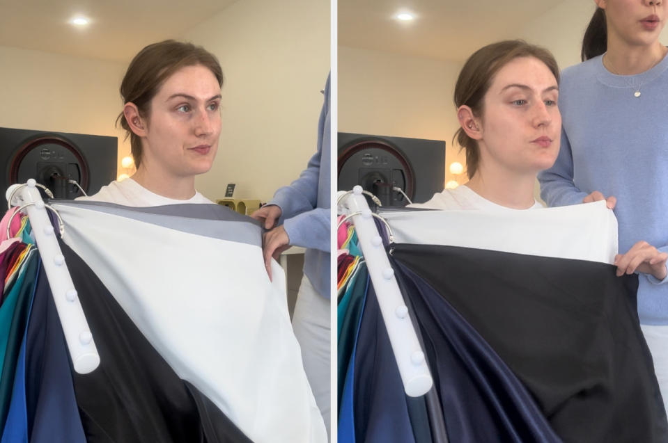 Two photos show a person with a neutral expression being draped with different colorful fabrics by another person