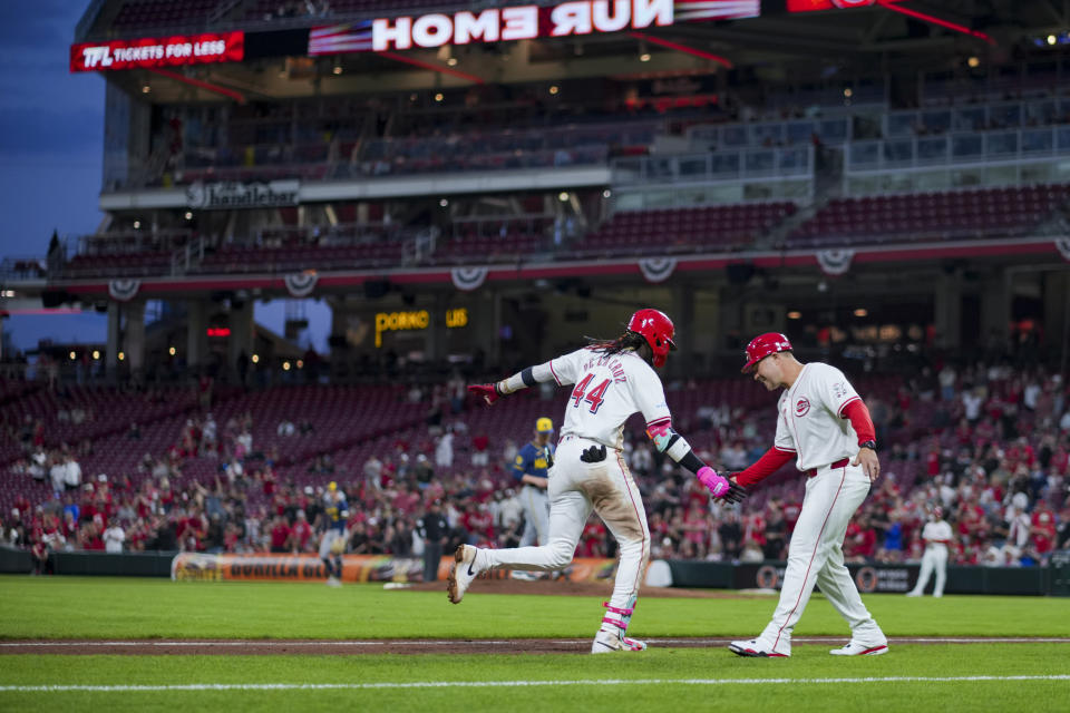 Cincinnati Reds' Elly De La Cruz, left, high-fives third base coach J.R. House, right, after hitting a solo home run during the fifth inning of a baseball game against the Milwaukee Brewers in Cincinnati, Monday, April 8, 2024. (AP Photo/Aaron Doster)