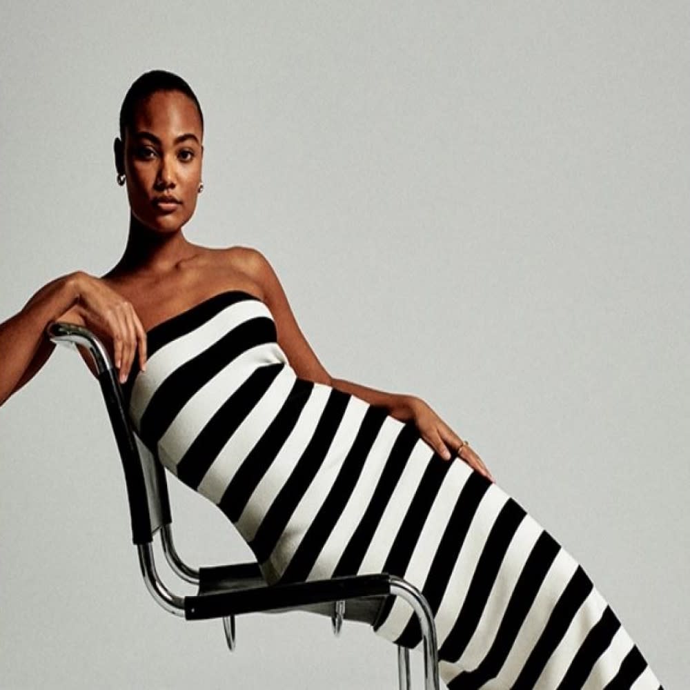  Woman in a black and white striped dress from Abercrombie posing on a chair. 