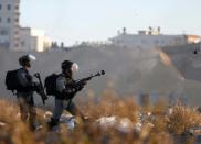 Israeli troops take position during clashes with Palestinian protesters near an Israeli checkpoint in the West Bank city of Ramallah on December 8, 2017