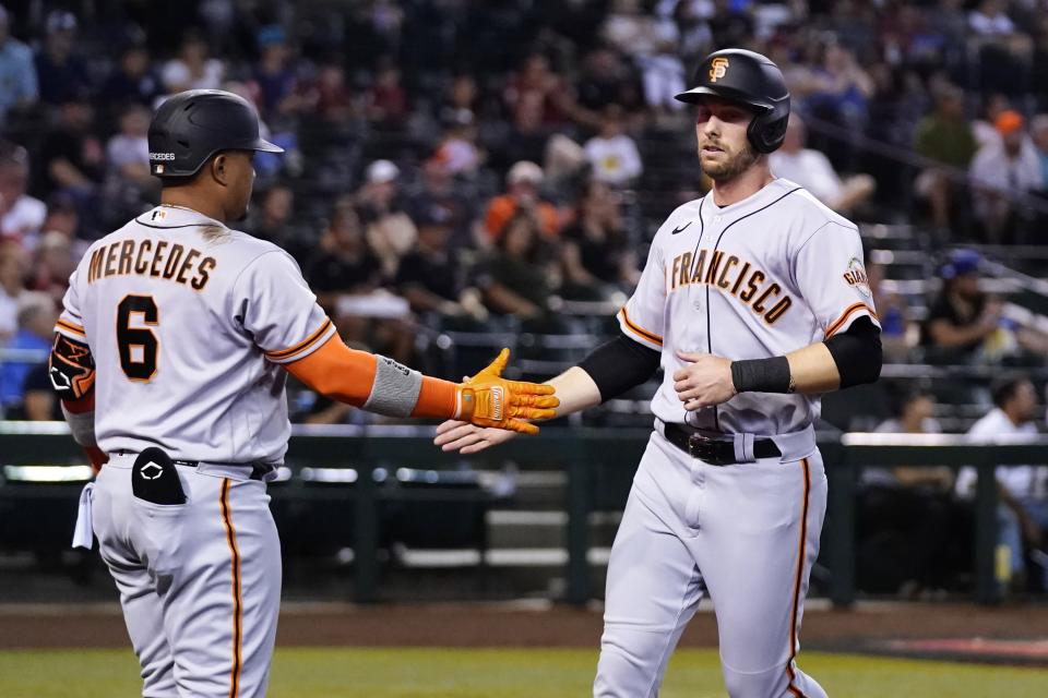 San Francisco Giants' Austin Slater, right, is congratulated by Yermin Mercedes (6) after scoring against the Arizona Diamondbacks during the fourth inning of a baseball game Tuesday, July 5, 2022, in Phoenix. (AP Photo/Ross D. Franklin)