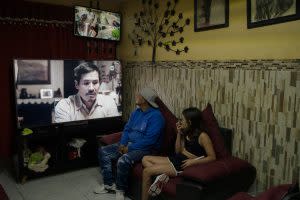 Raymundo Pérez, 29, mira las cámaras de la video vigilancia instaladas afuera de su casa al lado de su hija, quien mira la televisión, en su vivienda en León, Guanajuato, el 19 de junio del 2021. Foto: Fred Ramos