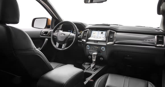 A view of the front seat and dash of the 2019 Ford Ranger Lariat. The seats have leather upholstery and the dash features a prominent touchscreen.