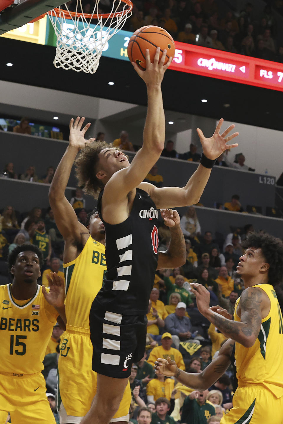 Cincinnati guard Dan Skillings (0) scores past Baylor defenders during the second half of an NCAA college basketball game Saturday, Jan. 13, 2024, in Waco, Texas. (AP Photo/Jerry Larson)