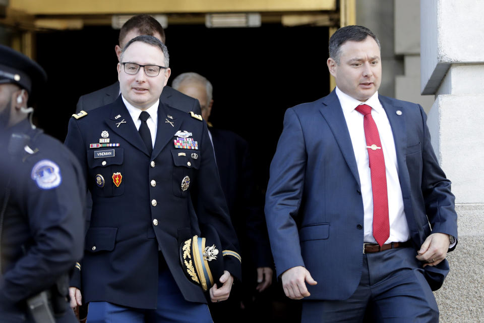 National Security Council aide Lt. Col. Alexander Vindman, left, walks with his twin brother, Army Lt. Col. Yevgeny Vindman, after testifying before the House Intelligence Committee on Capitol Hill in Washington, Tuesday, Nov. 19, 2019, during a public impeachment hearing of President Donald Trump's efforts to tie U.S. aid for Ukraine to investigations of his political opponents. (AP Photo/Julio Cortez)