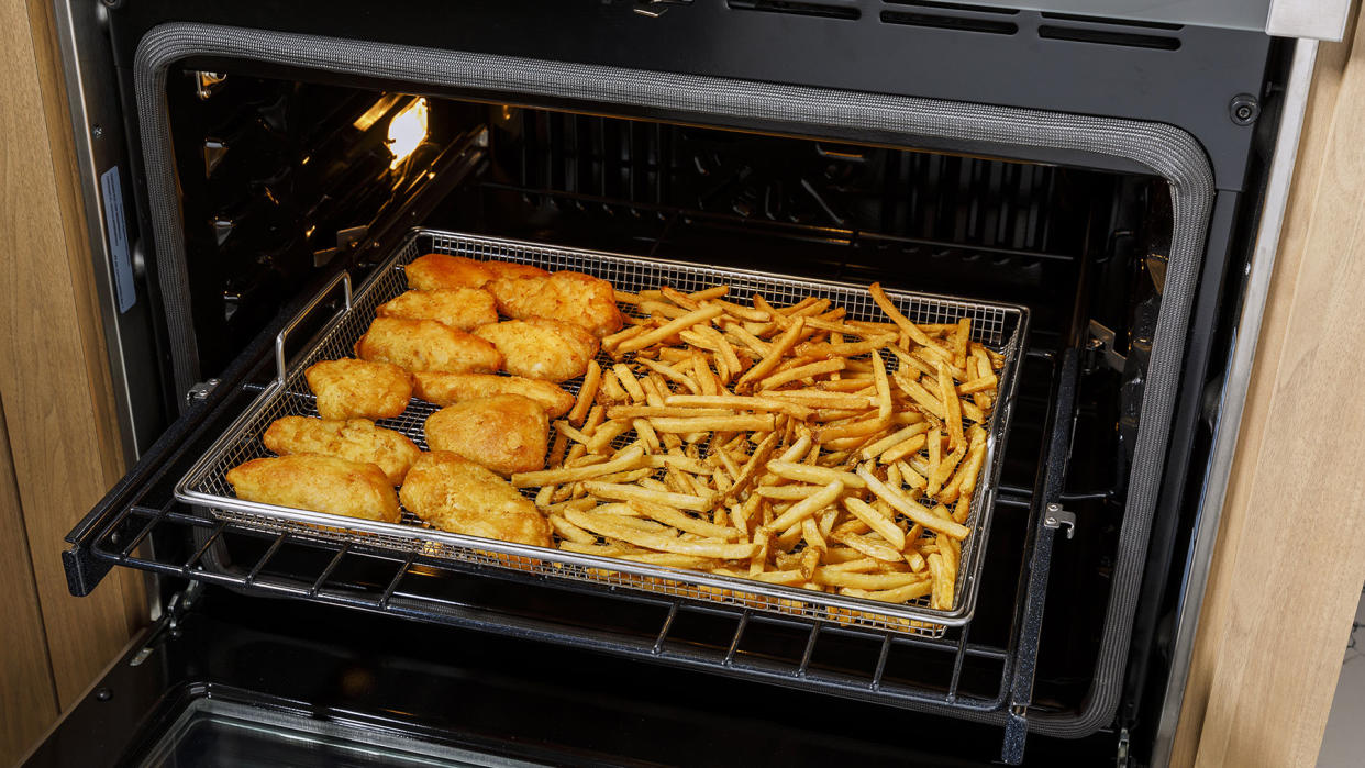  Food cooking on a air fryer rack in a GE Appliances range. 