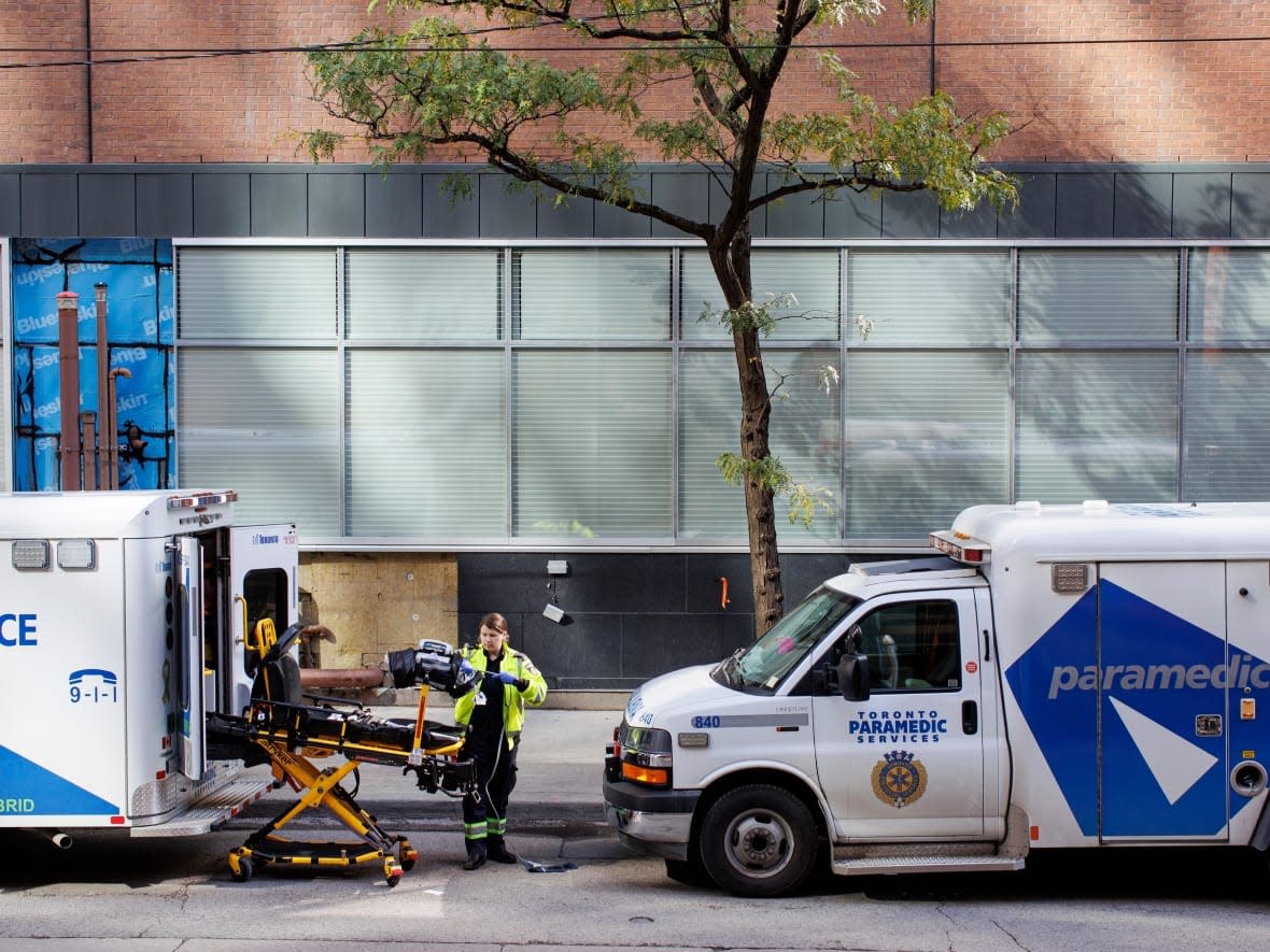 A paramedic is seen outside St. Michael's Hospital in Toronto on Oct. 14, 2022. Two men are facing fraud charges after police concluded an investigation into the awarding of a contract in 2015 to redevelop the hospital. (Evan Mitsui/CBC - image credit)