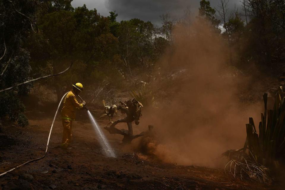 <p>PATRICK T. FALLON/AFP via Getty Images</p> A Maui County firefighter on Aug. 13