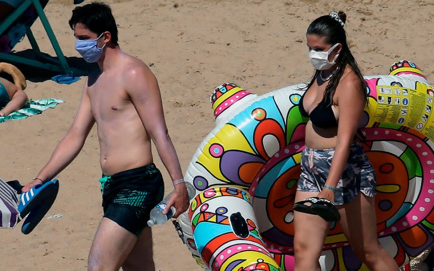 Sunseekers wear masks on the beach in Saint Jean de Luz, in southwestern France - Bob Edme /AP