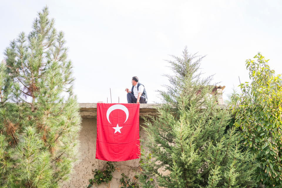 A man places a Turkish flag in the courtyard of a mosque before the funeral of a nine-month-old Syrian baby, who was killed during rocket and mortar attacks in Akçakale, Turkey, on Oct. 11, 2019. | Emanuele Satolli