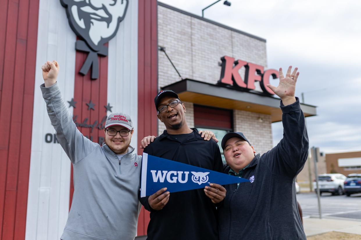 Photo of KFC employees holding an WGU sign.