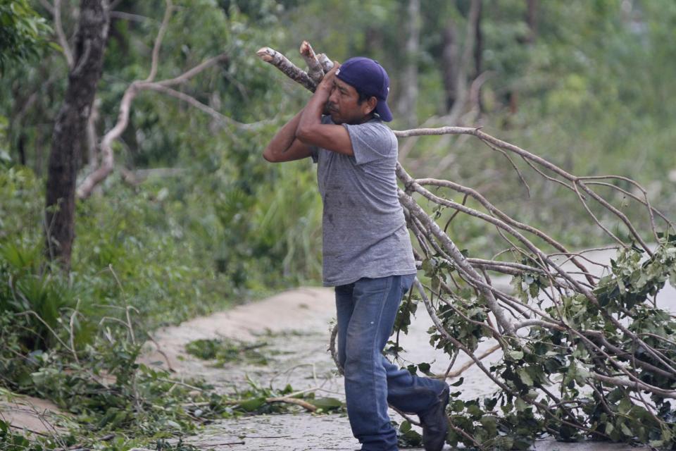 A worker cleans fallen branches after Hurricane Zeta passed through Playa del Carmen, Mexico, early Tuesday, Oct. 27, 2020. Zeta is leaving Mexico’s Yucatan Peninsula on a path that could hit New Orleans Wednesday night. (AP Photo/Tomas Stargardter)