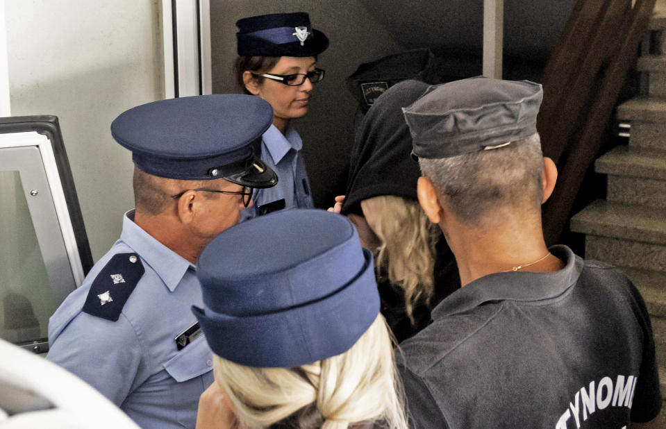 Police officers surround a British teenager accused of fasely claiming she was gang raped by Israeli tourists, as she leaves the Famagusta District Court in Paralimni in eastern Cyprus,on August 19, 2019 after her trial was postponed because of her request to be represented by a UK lawyer. - Initially, the 19-year-old woman had alleged that 12 Israelis gang raped her at the hotel where she was staying in the popular Ayia Napa resort on July 17. The young Israeli tourists were remanded in custody the next day. But hours before their second appearance in court five of them were released and sent home late the next day. (Photo by Iakovos Hatzistavrou / AFP)        (Photo credit should read IAKOVOS HATZISTAVROU/AFP via Getty Images)