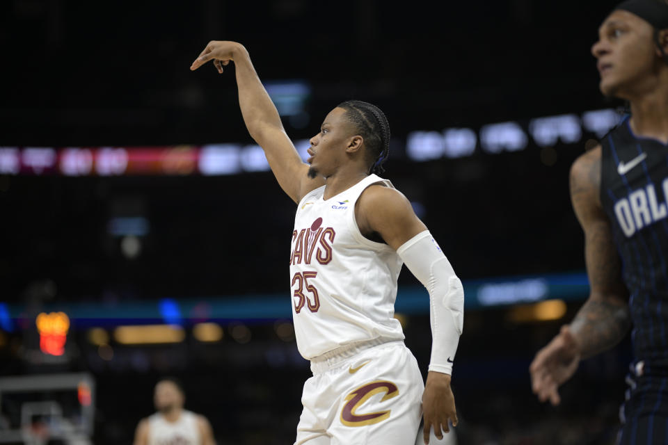 Cleveland Cavaliers forward Isaac Okoro (35) reacts after scoring a 3-pointer as Orlando Magic forward Paolo Banchero, right, watches during the first half of an NBA basketball game, Monday, Jan. 22, 2024, in Orlando, Fla. (AP Photo/Phelan M. Ebenhack)