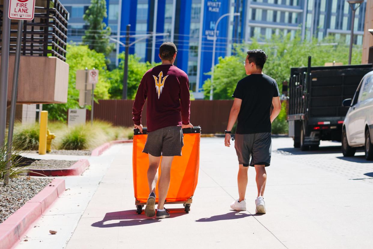 Suitemates, Isaac Gormley, left, and Yumin Han, right, walk to the parking garage together to unload Isaac's car as they move in to the dorms at ASU's Tempe campus Aug. 11, 2022.