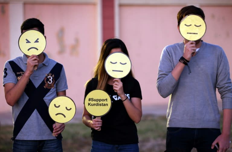 Iraqi Kurds hold a sad face emoji during a demonstration, against the escalating crisis with Baghdad, in front the UN Office in Arbil, the capital of the autonomous Kurdish region of northern Iraq, on October 17, 2017