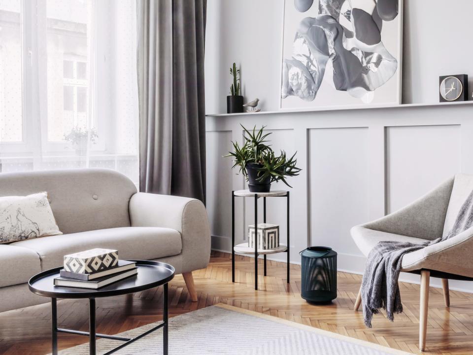 Living room with gray walls, artwork, curtain, chair, and couch