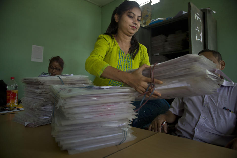 In this Friday, Aug. 30, 2019, file photo, a National Register of Citizens (NRC) officer arranges documents at an NRC center on the eve of the release of the final NRC draft in Gauhati, India. India has been embroiled in protests since December, when Parliament passed a bill amending the country's citizenship law. (AP Photo/Anupam Nath, File)