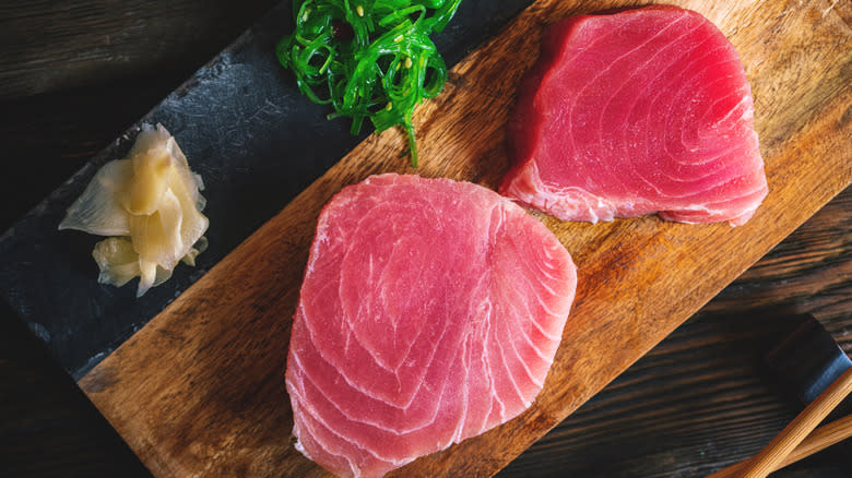 uncooked tuna steaks on board