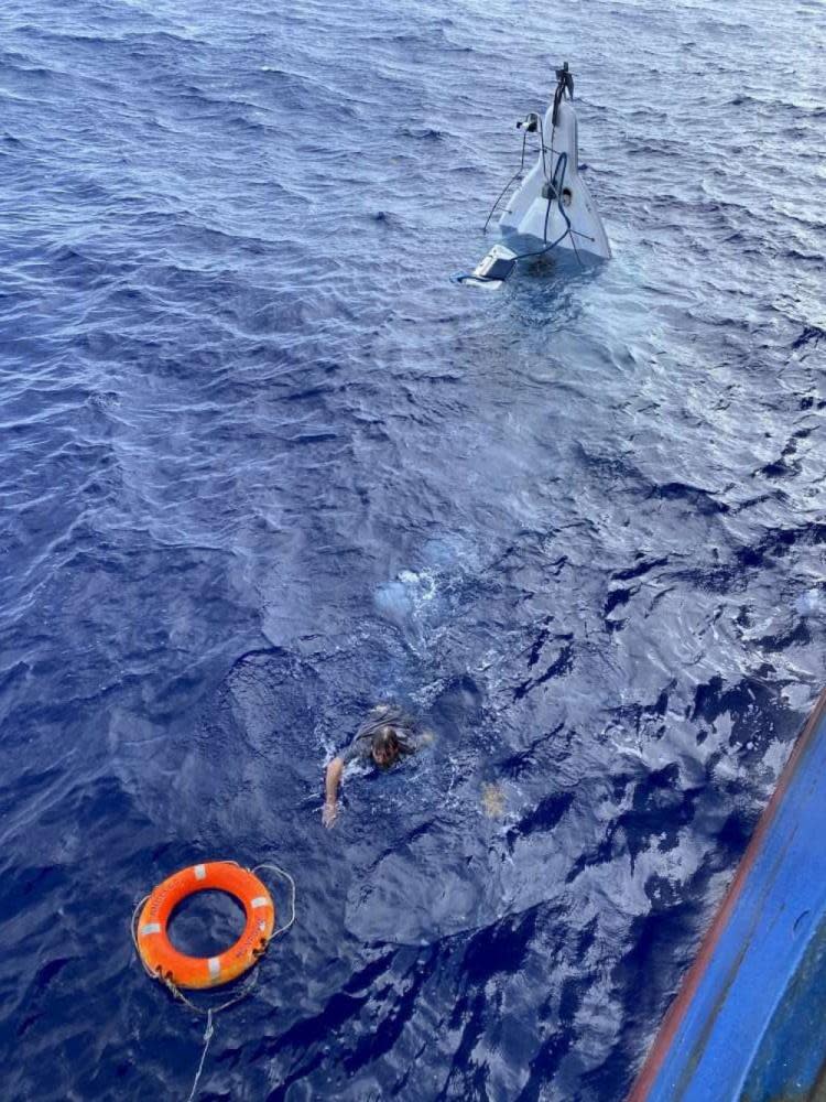 Stuart Bee swimming from his capsized boat to a buoy thrown by the crew of the Angeles cargo ship