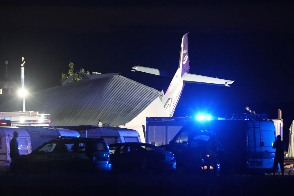 The tail of a Cessna 208 plane sticking out of a hangar after it crashed there in bad weather killing several people and injuring others, at a sky-diving centre in Chrcynno, central Poland, on Monday, July 17, 2023. (AP Photo/Czarek Sokolowski)