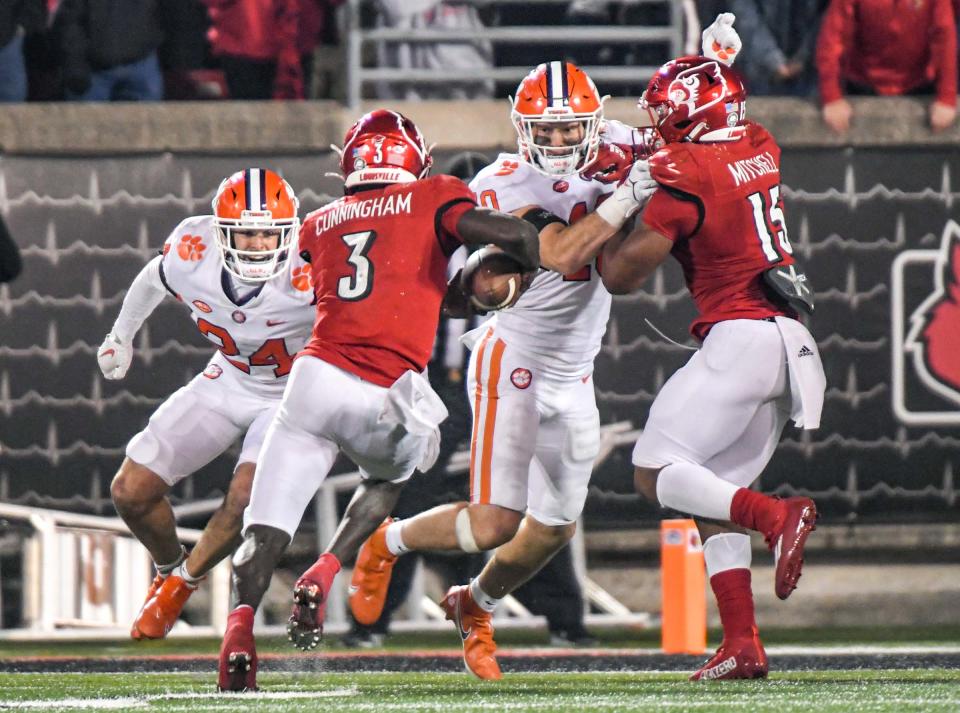 Clemson safety Nolan Turner (24) and linebacker Baylon Spector (10) get ready to tackle Louisville quarterback Malik Cunningham (3) on a 2nd-and-2 play with seconds left in the game during the fourth quarter at Cardinal Stadium in Louisville, Kentucky Saturday, November 6, 2021.