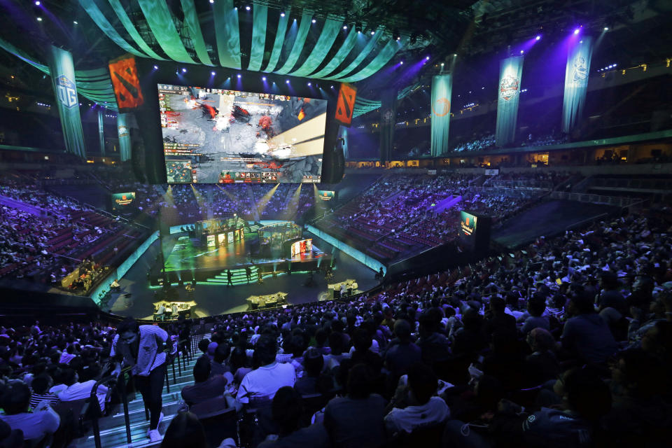 Fans look on at KeyArena during the International Dota 2 Championships Wednesday, Aug. 9, 2017, in Seattle. Members of the five-person eSport teams each select fantasy-world hero characters and the teams then face off for control of the game world's map. The championship, pitting 16 teams against each other for $24 million in prize money, runs through Saturday. (AP Photo/Elaine Thompson)