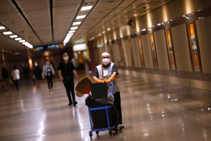 A cleaner wears a protective face mask due to coronavirus disease (COVID-19) outbreak, at a train station in Bangkok