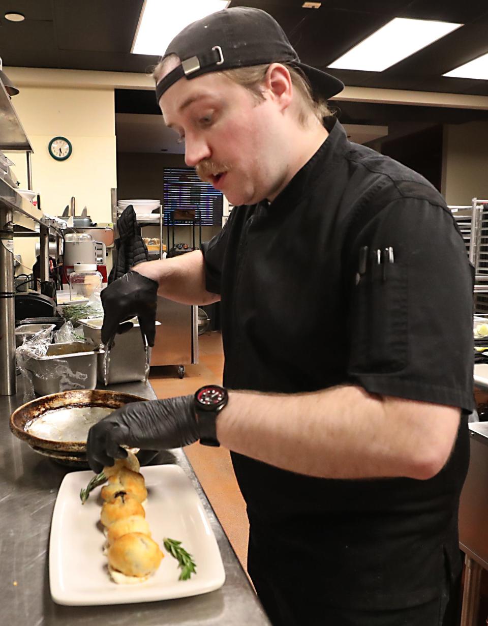 Ian Lotz, partner and chef at the new restaurant and bar The Circle of 5ths, plates wellington bites in the kitchen of the restaurant located above Blue Jazz+ in Akron.