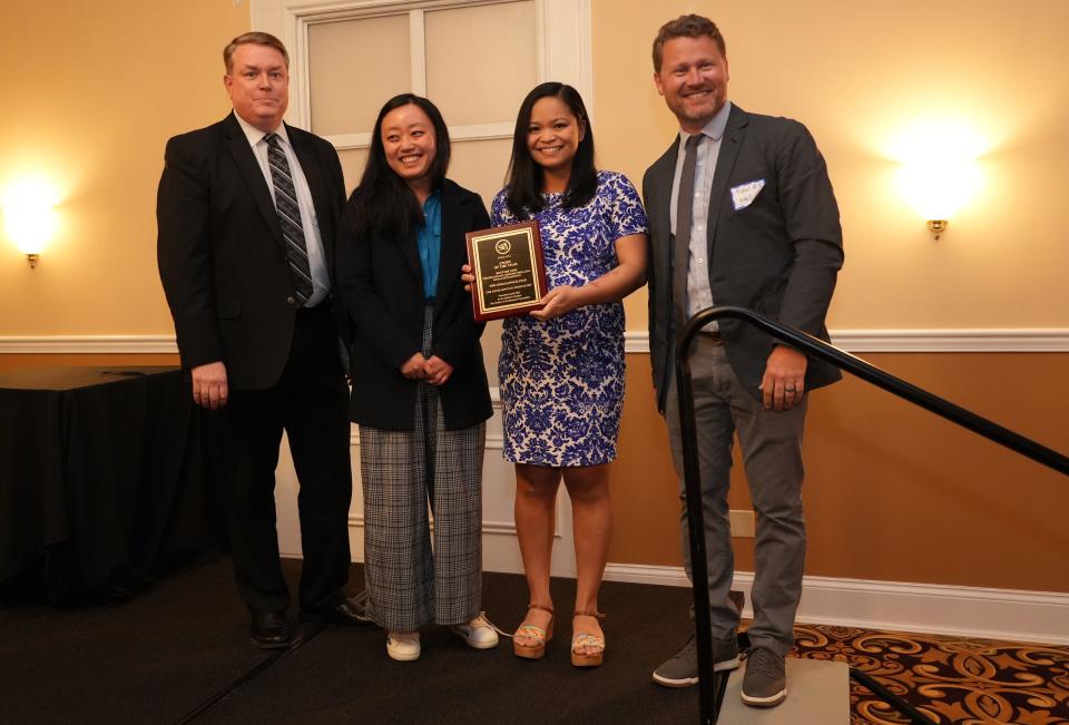 Scott Uecker (left), a SPJ board member, presents the award for Story of the Year to IndyStar reporters Binghui Huang and Kristine Phillips, and photographer Mykal McEldowney, for their work on Bottom Line, which explored the failures of IOSHA during the COVID-19 pandemic. 