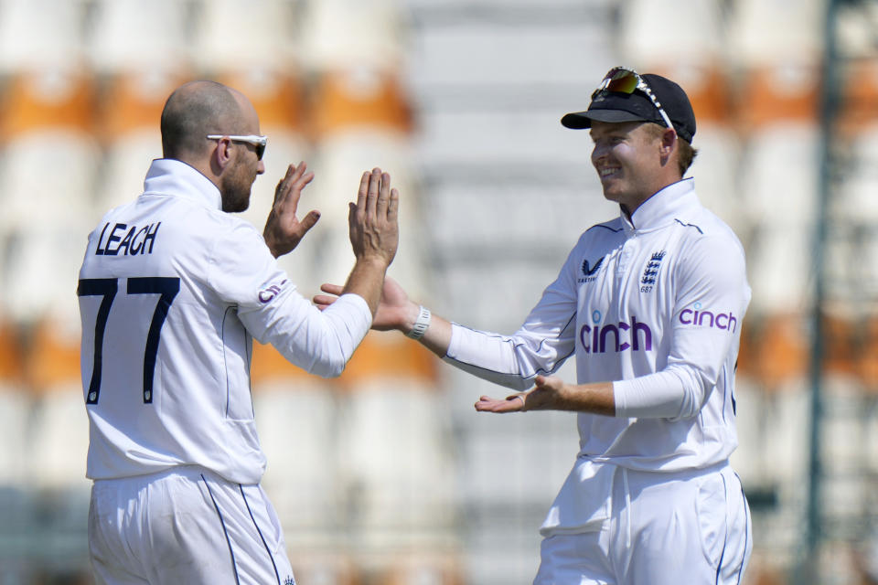 England's Jack Leach, left, celebrates with Ollie Pope after taking the wicket of Pakistan's Shaheen Shah Afridi during the fifth day of the first test cricket match between Pakistan and England, in Multan, Pakistan, Friday, Oct. 11, 2024. (AP Photo/Anjum Naveed)