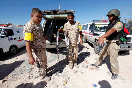 A fighter of Libyan forces allied with the U.N.-backed government holds an explosive belt left behind by Islamic State militants near the eastern frontline, in Sirte, Libya, October 20, 2016. REUTERS/Ismail Zitouny