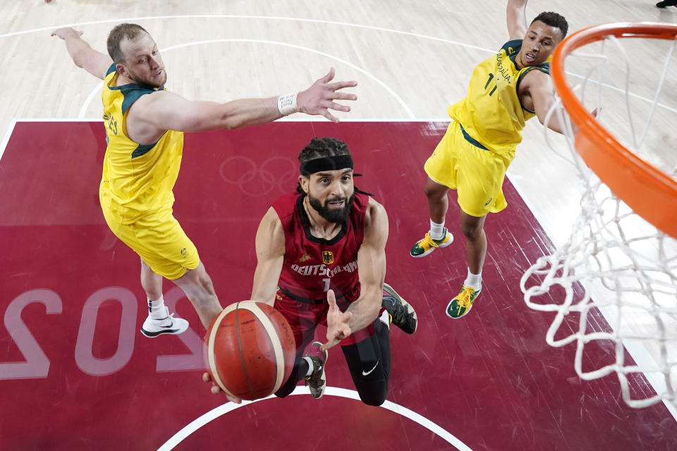 Germany's Joshiko Saibou (1) drives to the basket against Australia's Joe Ingles (7) and Dante Exum (11) during a men's basketball preliminary round game at the 2020 Summer Olympics, Saturday, July 31, 2021, in Saitama, Japan. (AP Photo/Eric Gay)