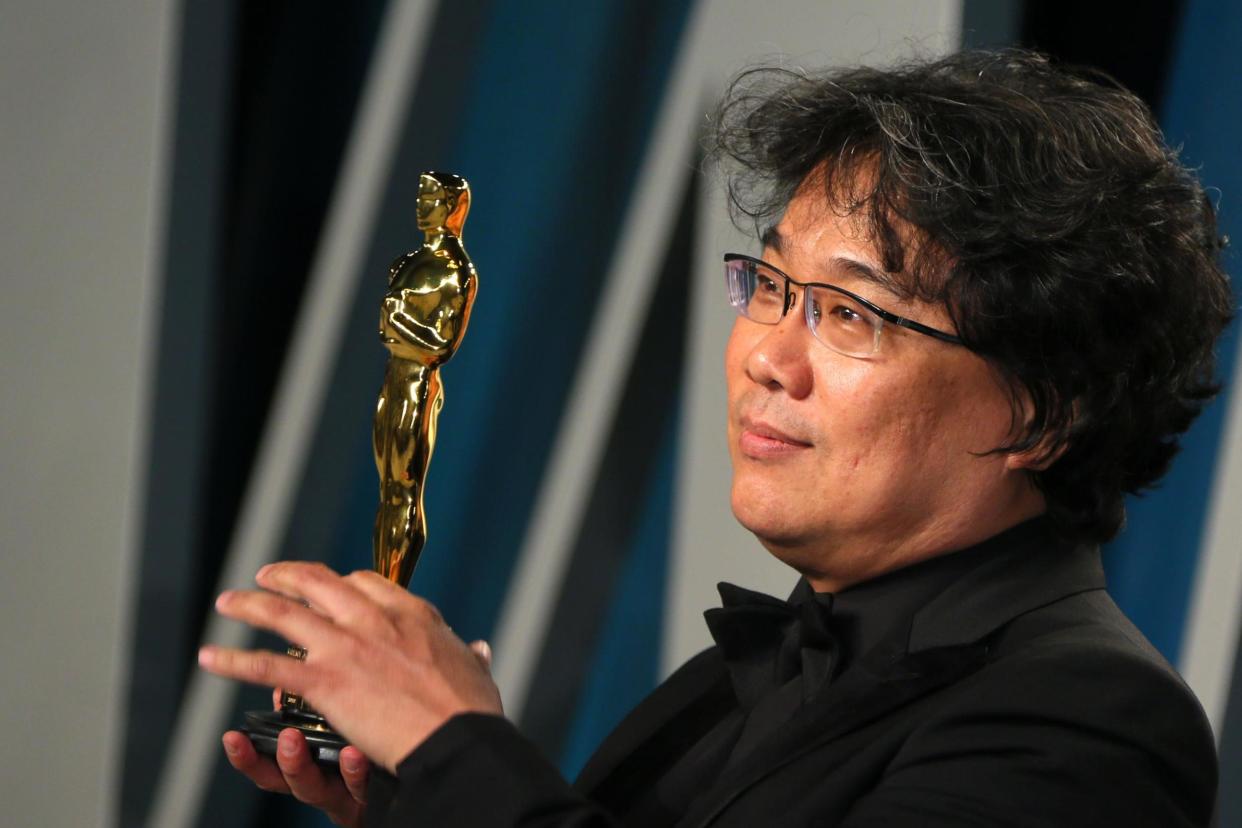 Director Bong Joon-ho poses with the Oscar for Best Screenplay for Parasite: AFP via Getty Images