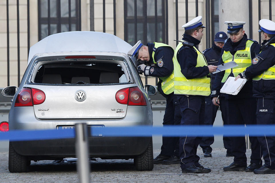 Police officers examine a car in the driveway to the Presidential Palace in Warsaw, Poland, Tuesday, Jan. 22, 2019 after a man rammed the car into a metal barrier protecting the driveway. The man was driving the wrong way and hit a policeman who was trying to stop him before ramming into the barrier. (AP Photo/Czarek Sokolowski)