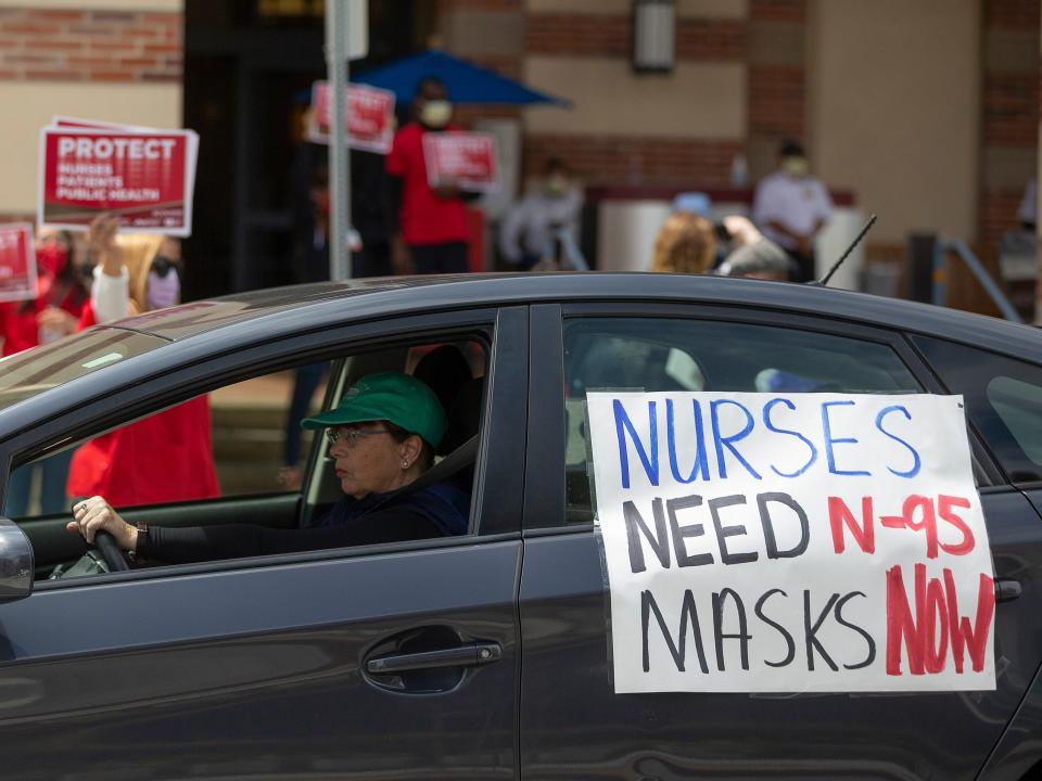 FILE - In this April 13, 2020, file photo, a car passes nurses protesting the lack of N95 respirators and other Personal Protective Equipment outside the UCLA Medical Center, Santa Monica amid the coronavirus pandemic in Santa Monica, Calif. An Associated Press review of more than 20 states found that before the coronavirus outbreak many had at least a modest supply of N95 masks, gowns, gloves and other medical equipment. But those were often well past their expiration dates — left over from the H1N1 influenza outbreak a decade ago. (AP Photo/Damian Dovarganes)