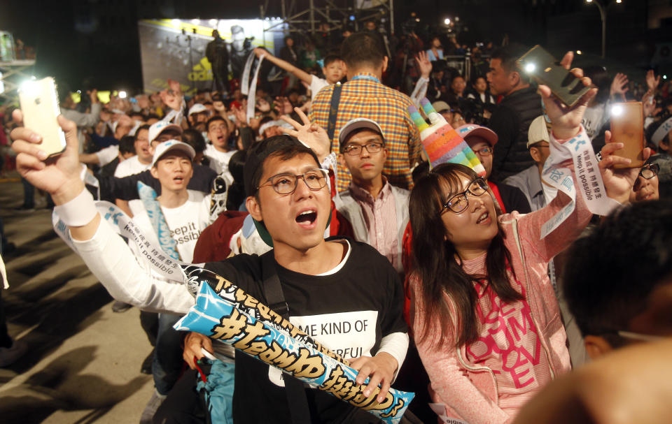 Supporters of Taipei city mayor and city mayoral candidate Ko Wen-je cheer for Ko's victory in Taipei, Taiwan, Sunday early morning, Nov. 25, 2018. Taiwan's ruling party suffered a major defeat Saturday in local elections seen as a referendum on the administration of the island's independence-leaning president amid growing economic and political pressure from China. (AP Photo/Chiang Ying-ying)