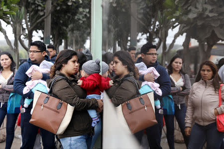 Venezuelan migrants wait at the Interpol headquarters to get paperwork needed for a temporary residency permit in Lima, Peru, August 16, 2018. REUTERS/Mariana Bazo